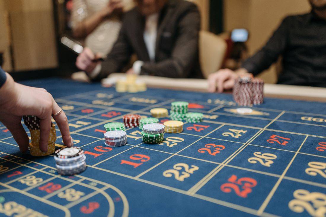 Tangan menempatkan chip di atas meja permainan